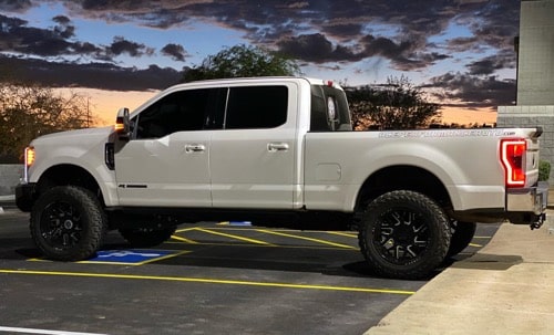 White truck in parking lot and sunset; Does Installing Aftermarket Tires Ruin My Warranty? 