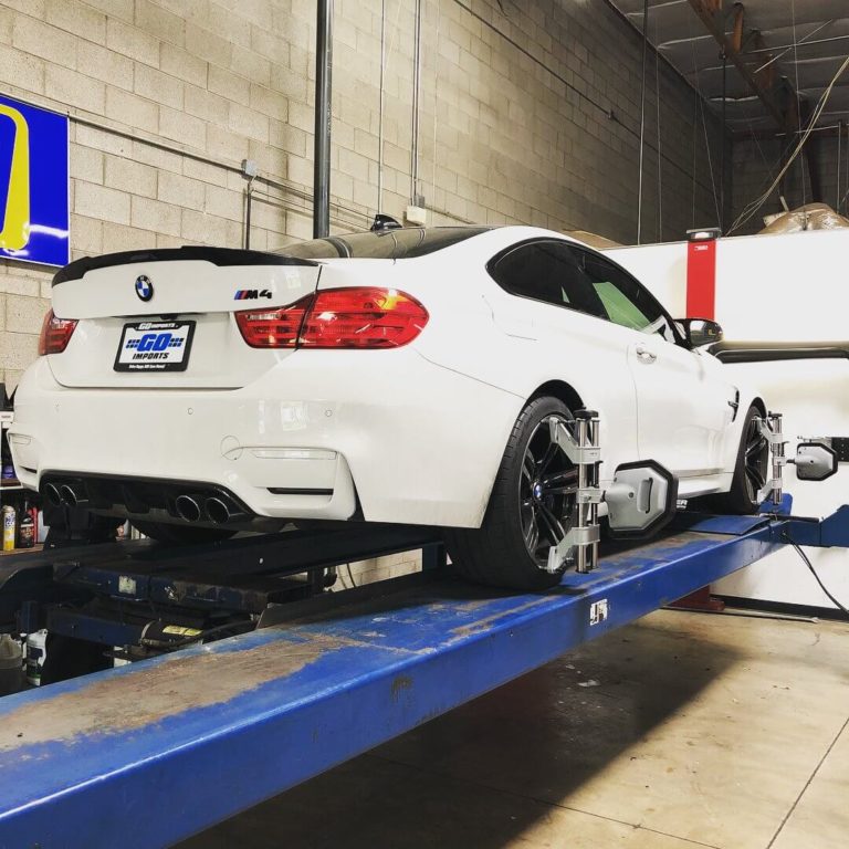 A white M4 BMW on-top of a blue car lift in Gilbert, AZ
