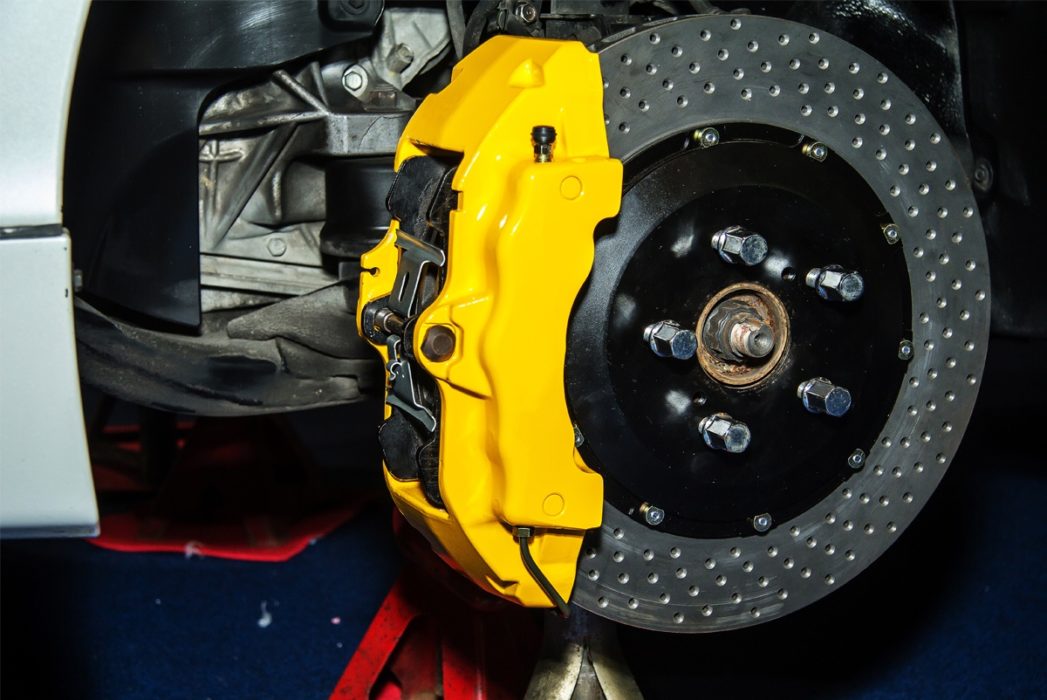 Brakes on a vehicle shown with the tire off; Brake repair and services in Gilbert, AZ