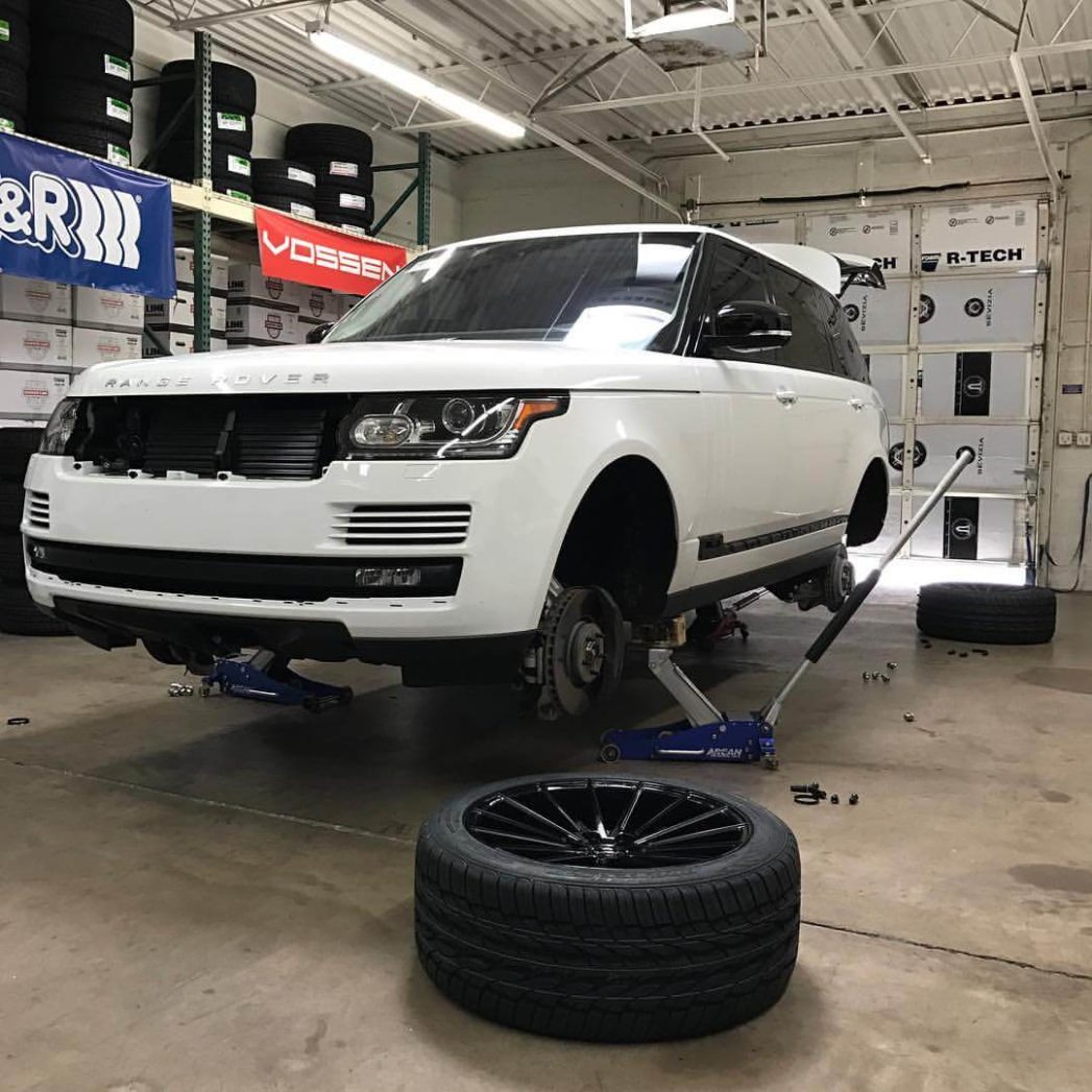 A white range rover raised up without tires in Gilbert, AZ