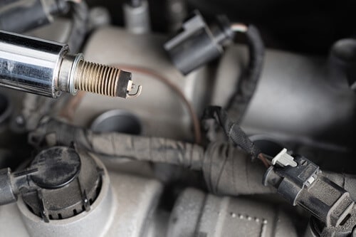 Why You Need to Change the Wires When Replacing Spark Plugs at Ace Performance Automotive in Gilbert Az. ; closeup image of spark plug and wire unhinged