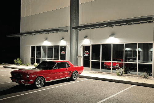 Welcome to Queen Creek AZ's Newest NAPA Auto Care Center Ace Performance Automotive. Image of APA at night with classic redone red mustang car parked in front