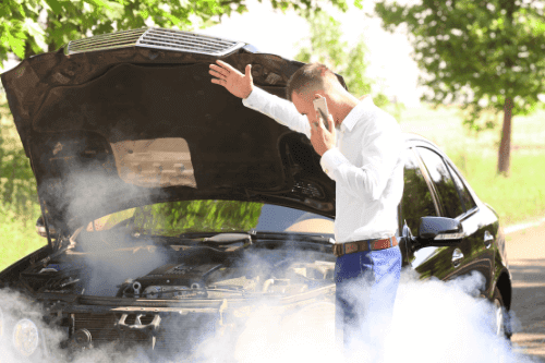 How to Prevent Your Car from Overheating in Arizona with Ace Performance Auto in Gilbert, AZ & Queen’s Creek, AZ. Image of a man on the phone calling for help for his overheating car.