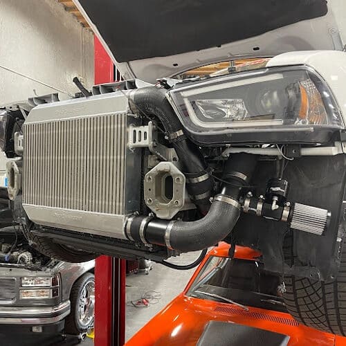 Chill Out Your Engine With a Coolant Fluid Flush | Ace Performance in Gilbert, AZ & Queen Creek, AZ. Closeup image of a naked radiator being repaired in an auto garage shop.