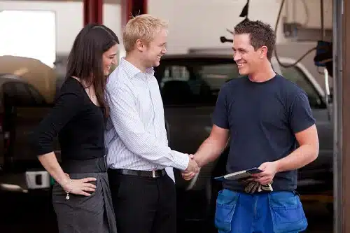 Four Signs You Found The Right Auto Repair Shop | APA Total Care in Gilbert, AZ. Image of a happy couple shaking hands with an auto mechanic. The couple is happy with the mechanic’s service.